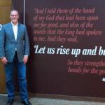 President Scott Moats in front of the new AU mission mural, Let Us Rise Up and Build