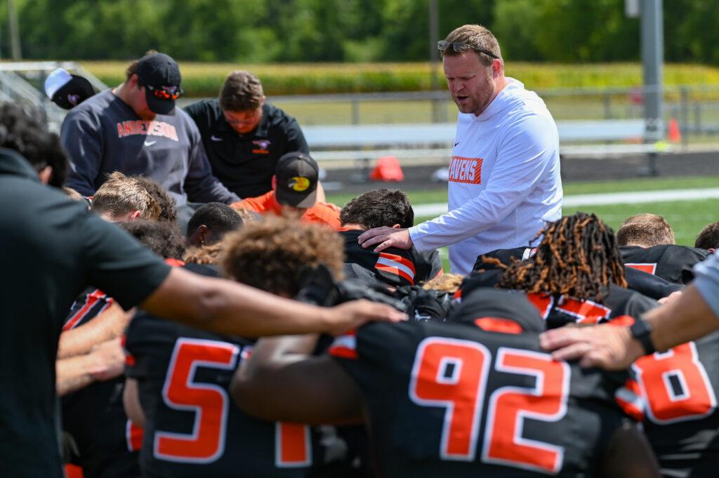 Coach prays over the AU Football team