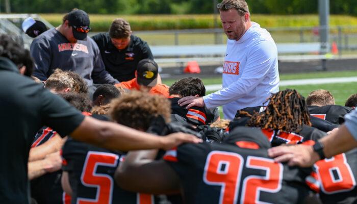Coach prays over the AU Football team