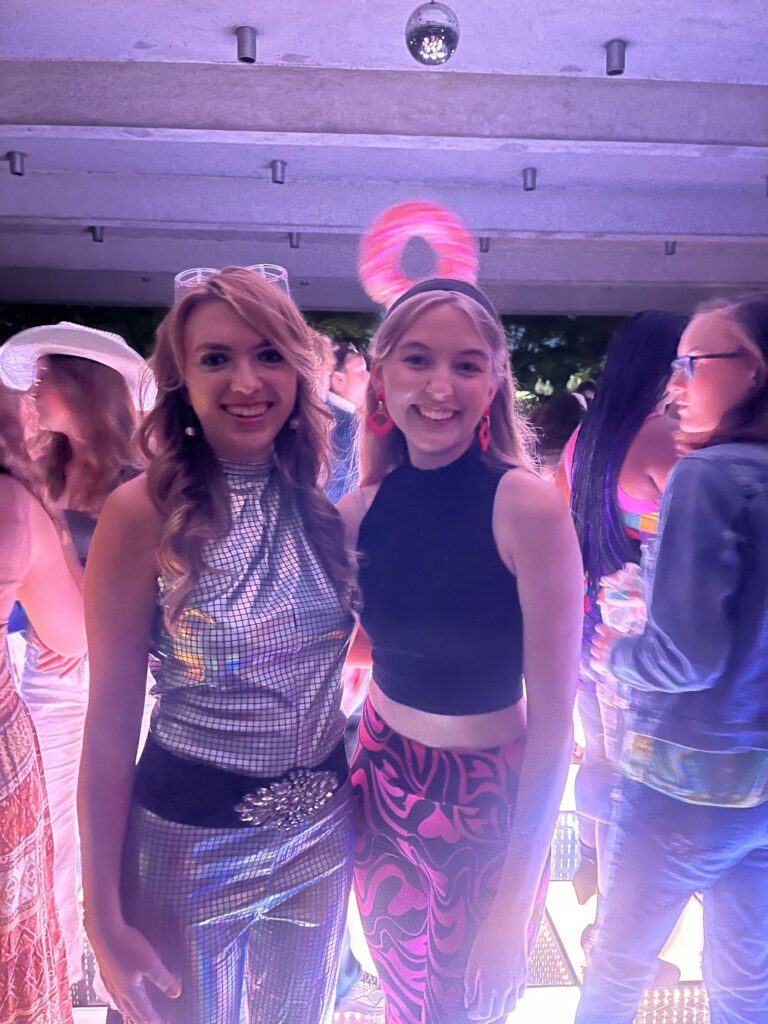 Two students smiling in their disco attire