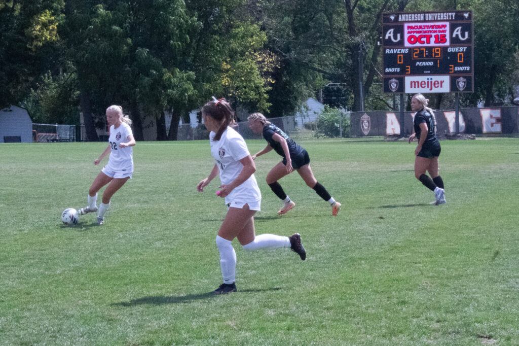 Au soccer player no. 32 dribbles the ball with other players and opponents behind her