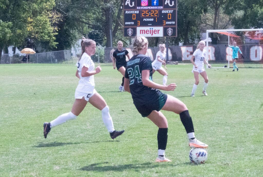 AU soccer player no. 20 chases after an opponent dribbling the ball
