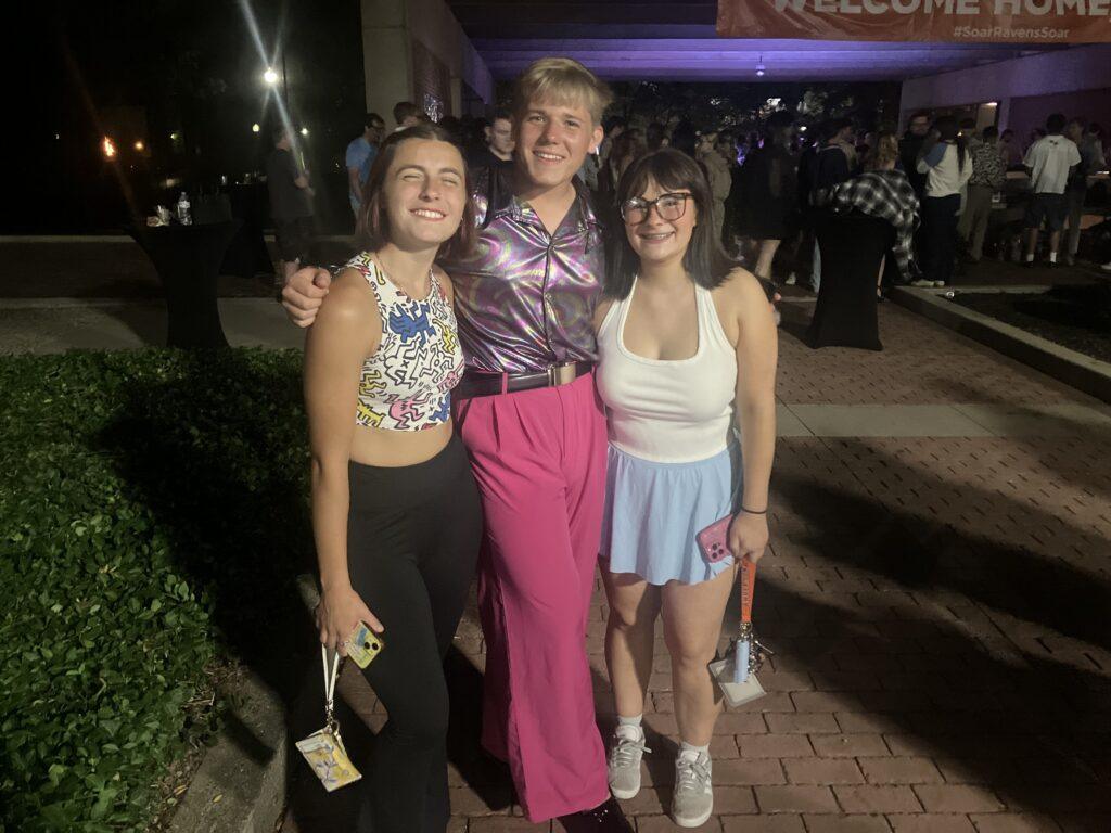 Three friends in disco attire posing
