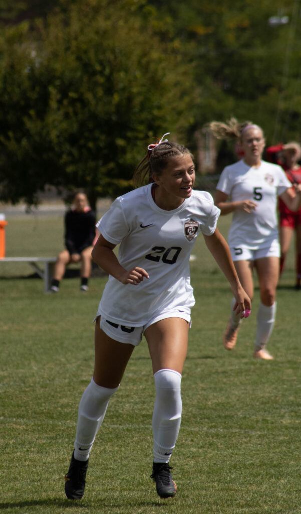 AU Soccer player no. 20 smiles as she runs on the field