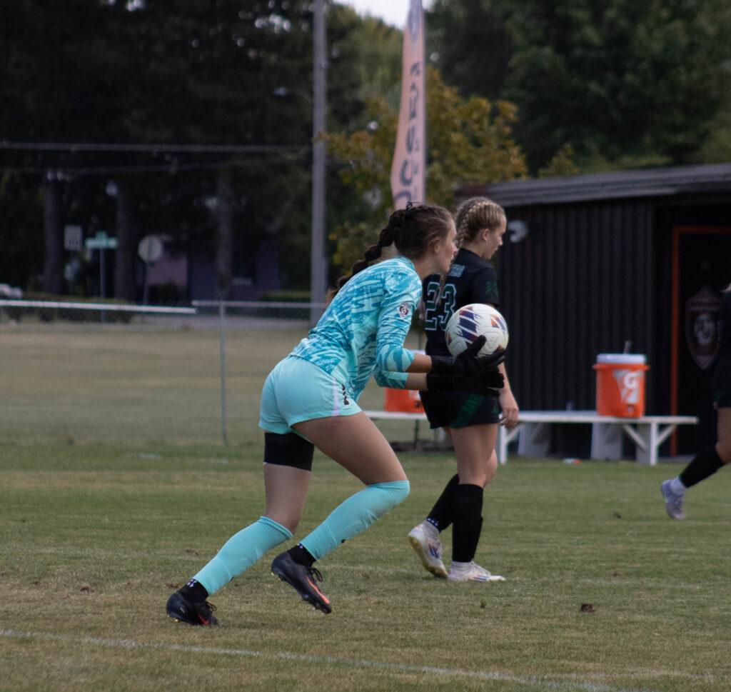 AU soccer goalkeeper prepares to pass the ball
