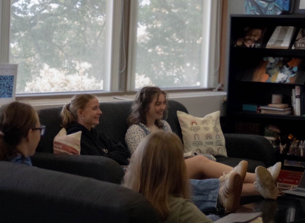Students in Becca Palmer's chapel sitting on couches happily