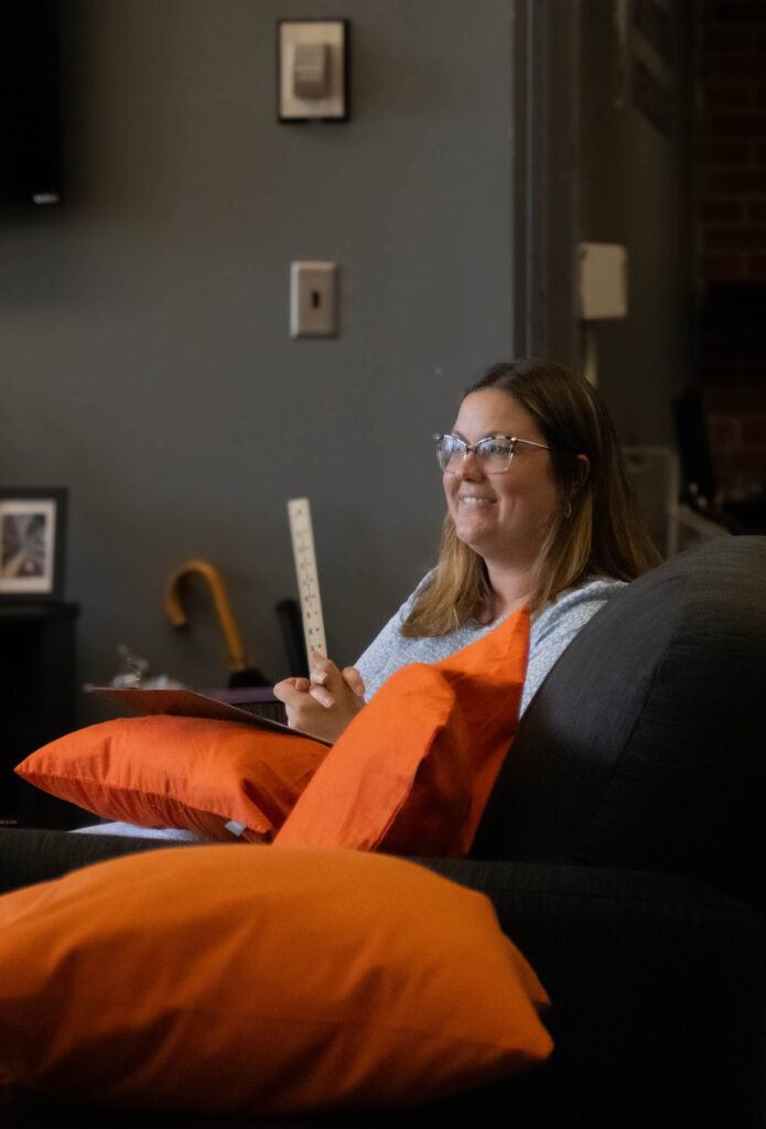 Director of Spiritual Formation Becca Palmer sitting on a couch in the SAIL office