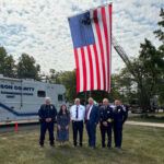 The Remembrance day speakers posing in front of a large American flag