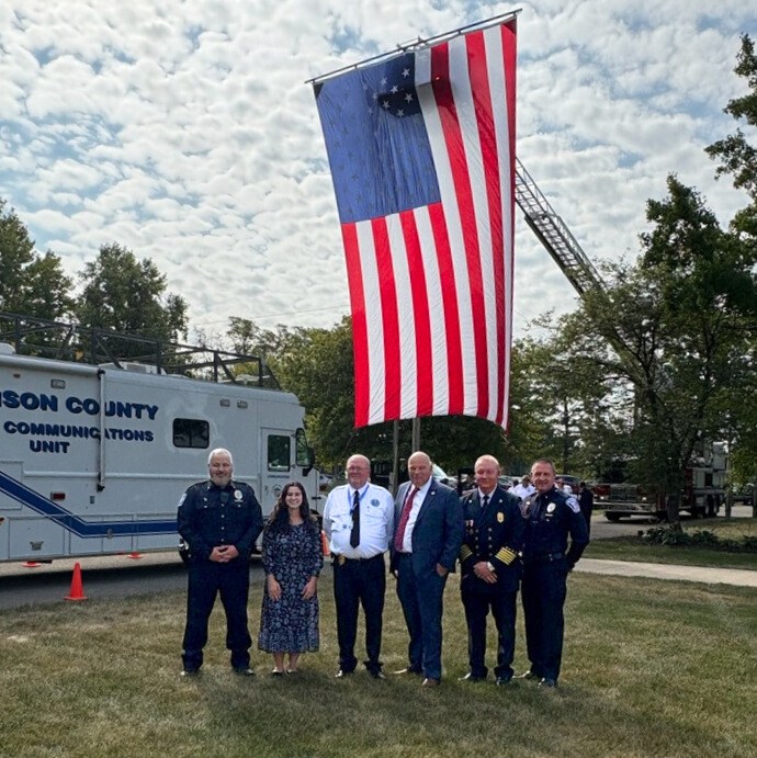 The Remembrance day speakers posing in front of a large American flag