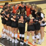 The Women's Volleyball team huddling together
