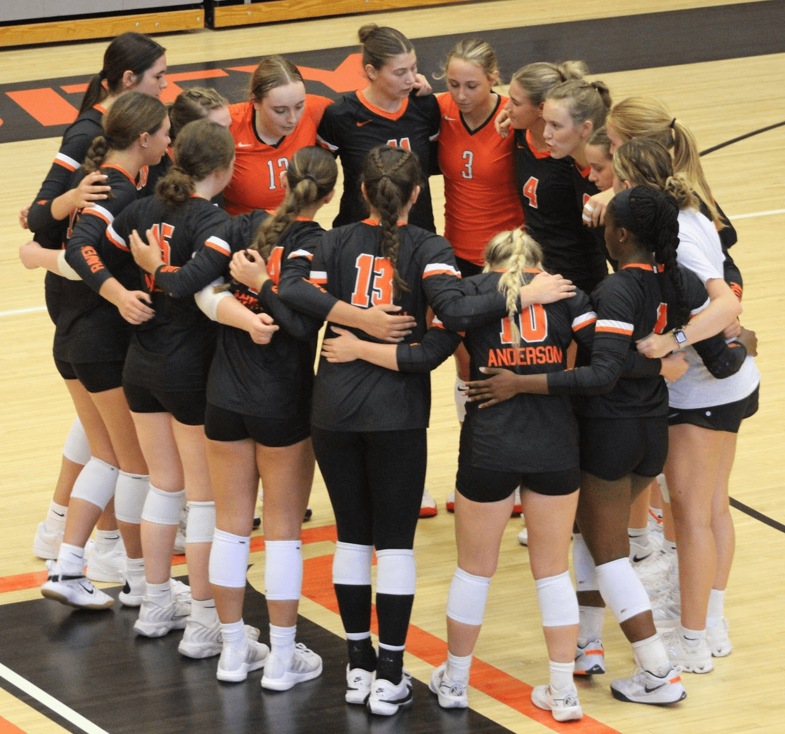 The Women's Volleyball team huddling together