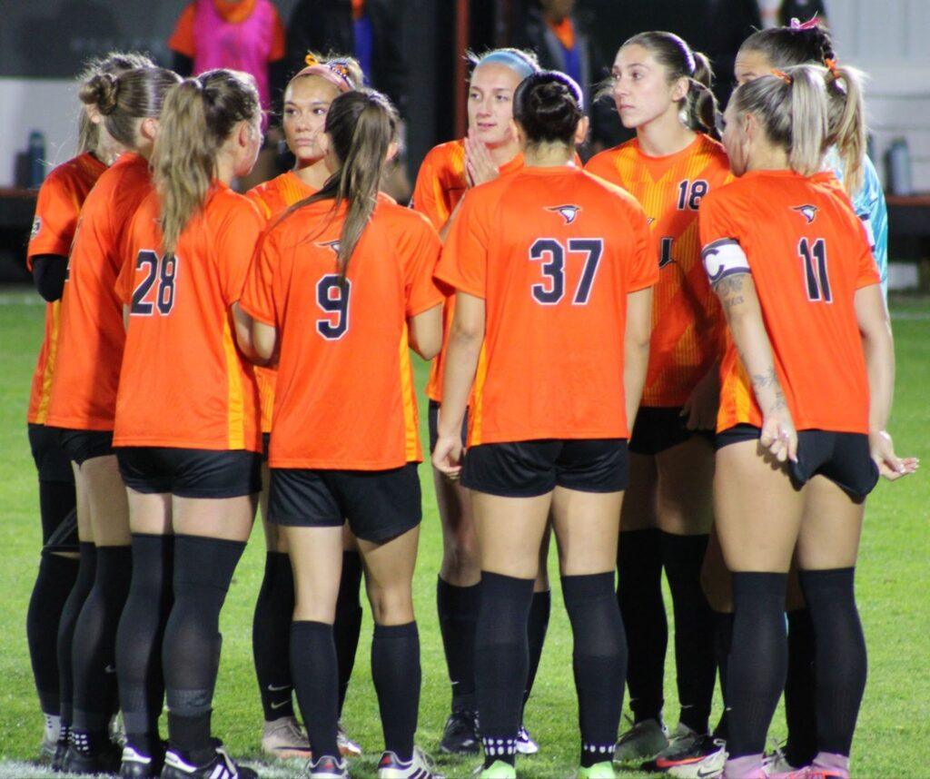 AU women's soccer team in a huddle