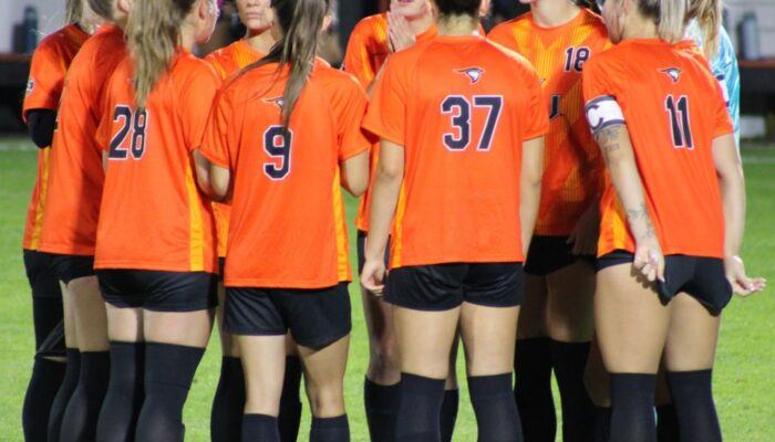 AU women's soccer team in a huddle